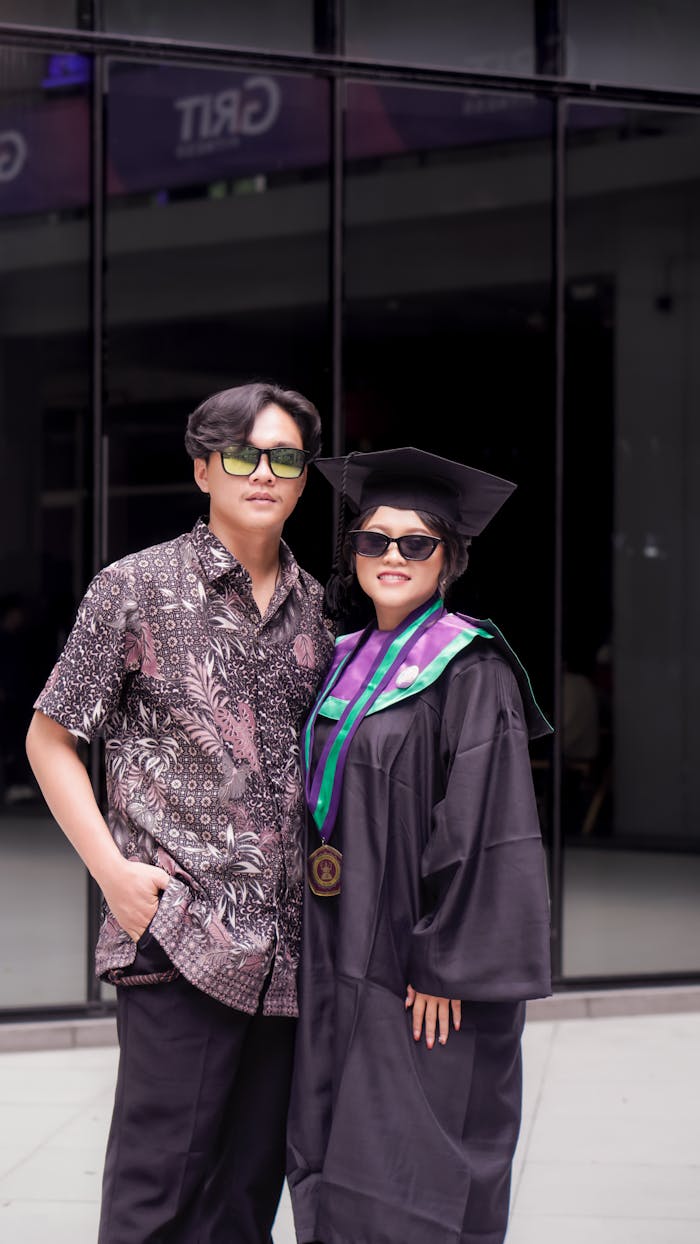 Two friends celebrate graduation outdoors, capturing a memorable moment of achievement.