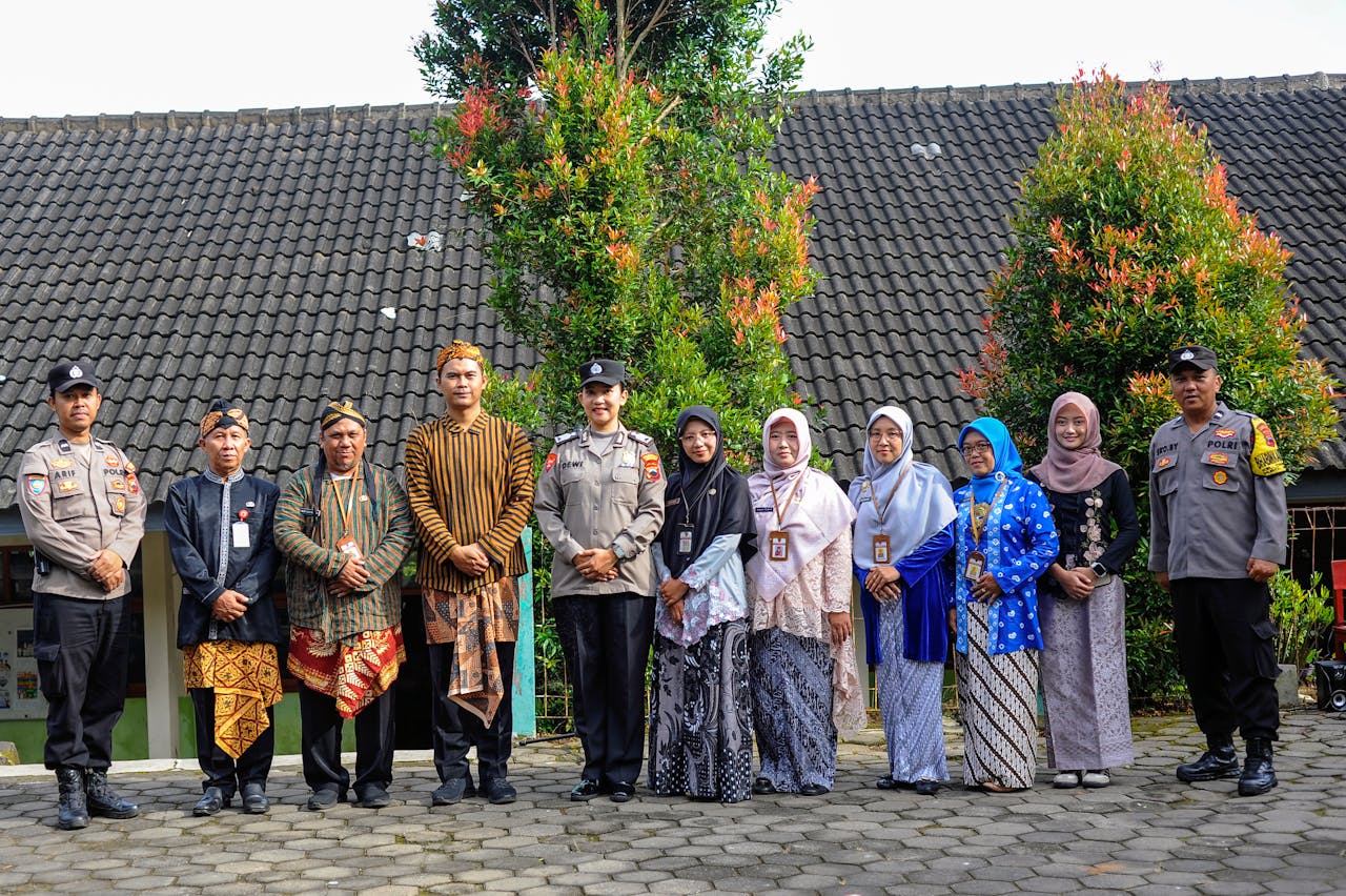 Group posing in traditional attire and police uniforms outdoors, showcasing cultural diversity.